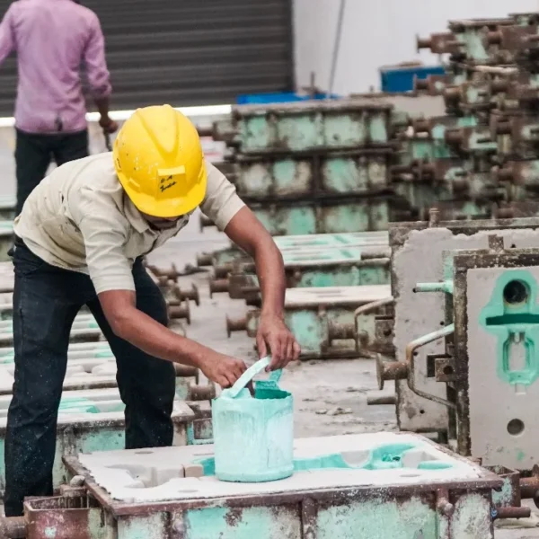 Worker applying coating to industrial sand-casting moulds